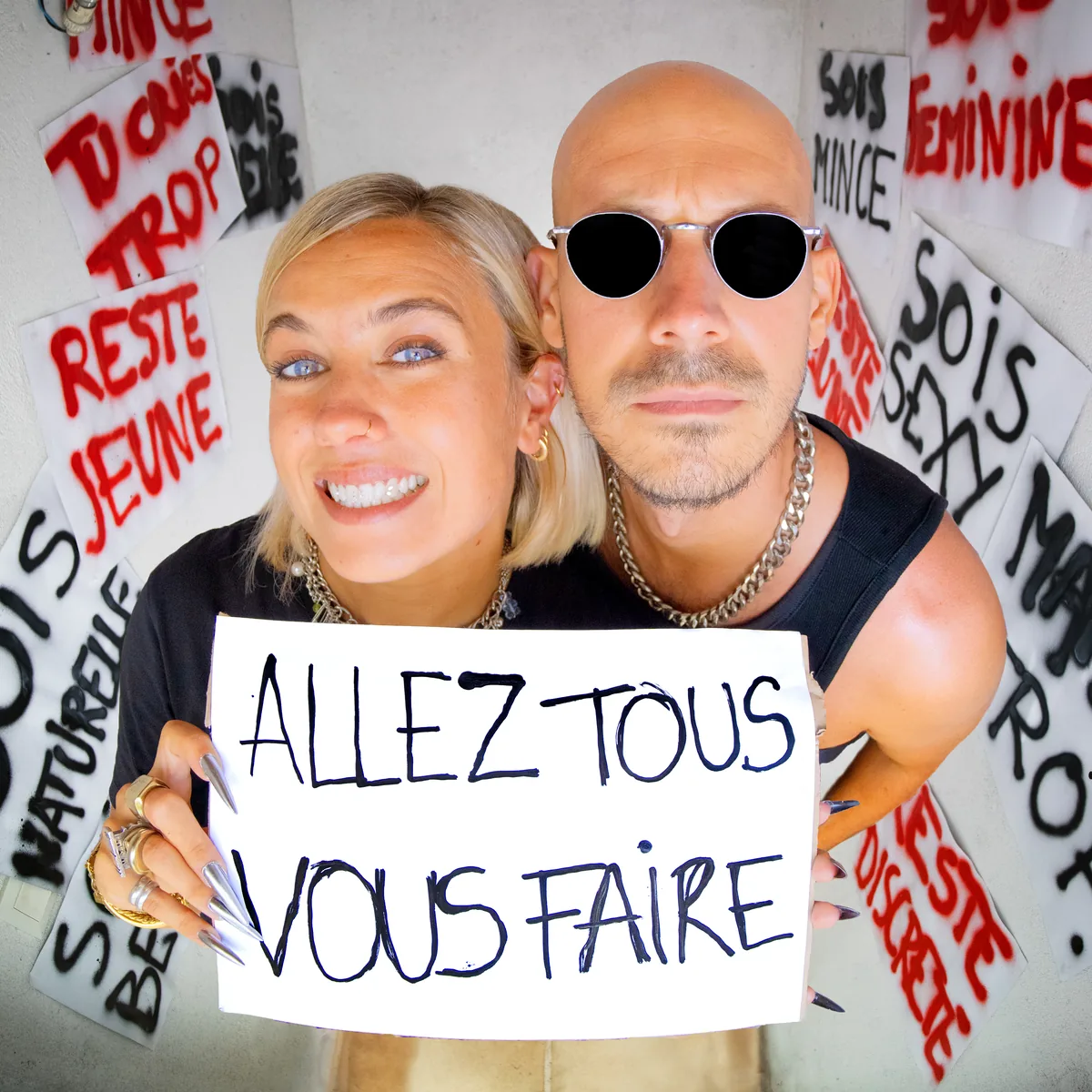 Pochette du single Allez tous vous faire de Jive Me : Tara tient une pancarte « Allez tous vous faire » devant un mur de messages