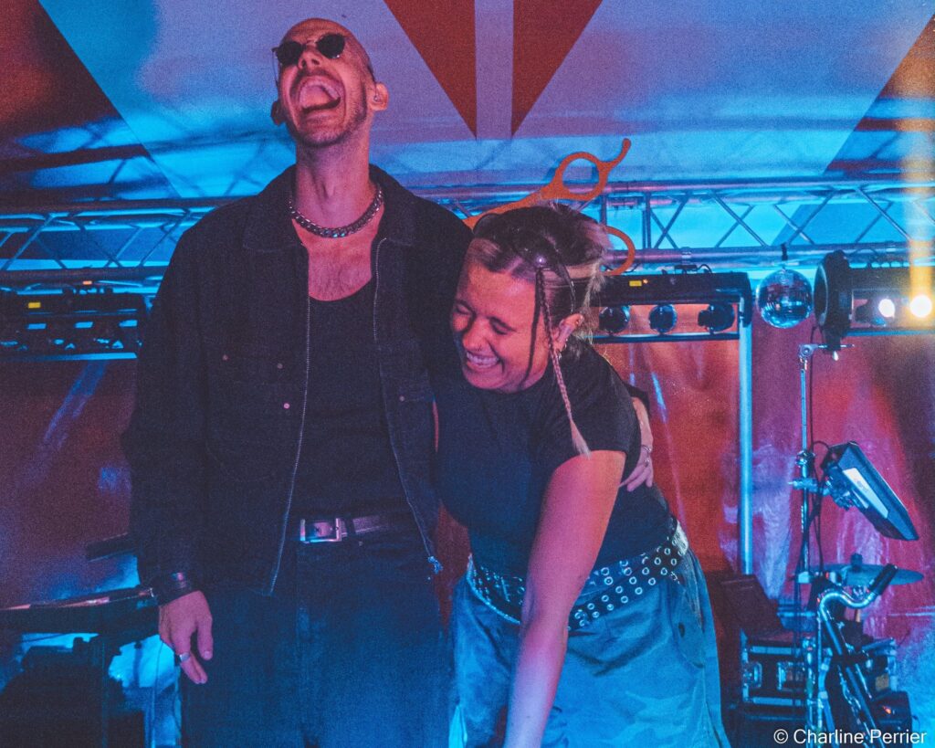 Baptiste et Tara de Jive Me éclatent de rire sur la scène d'un festival