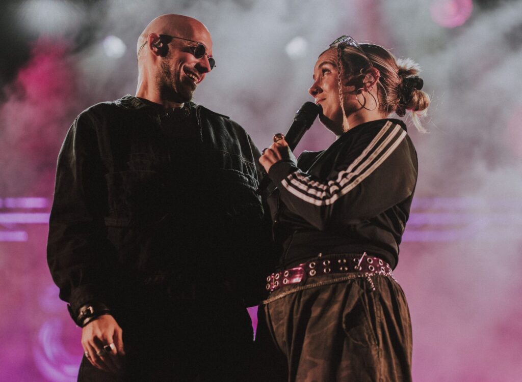 Baptiste et Tara de Jive Me sur scène en festival, dans la fumée rose, Tara au micro